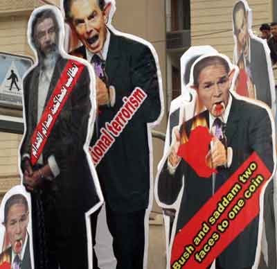 Iraqi Shi'ites loyal to cleric Moqtada al-Sadr hold cut-outs of British Prime Minister Tony Blair (C), former Iraqi president Saddam Hussein (L), and U.S. President George W. Bush during a protest rally in Baghdad April 9, 2005. The rally was called on the second anniversary of the fall of Baghdad with protestors demanding an end to the U.S. military presence in Iraq and a speedy trial for former president Saddam Hussein. [Reuters]